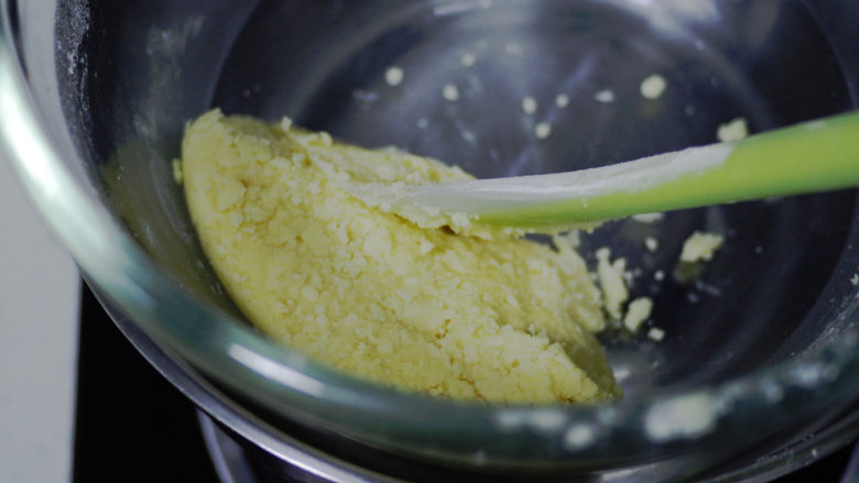黄桃乳酪派,倒入冷藏好的蛋液，拌匀后用刮刀归置在打蛋盆边上.
