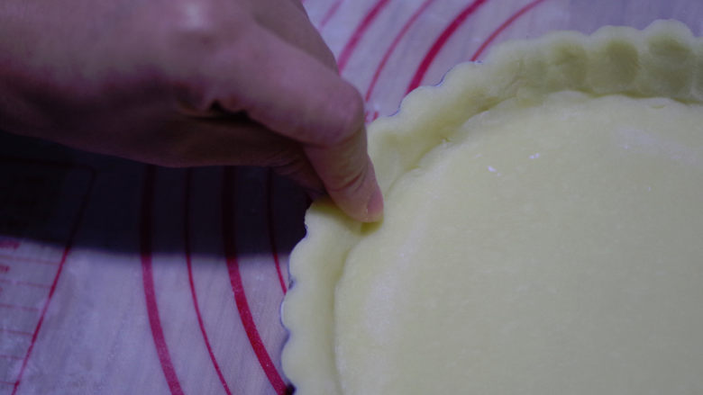 黄桃乳酪派,用食指在模具边缘捏出花形，面胚刚好高出模具2mm。
