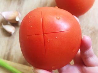 番茄鸡蛋面—家的味道,番茄顶部用刀切十字，方便一会剥皮。
