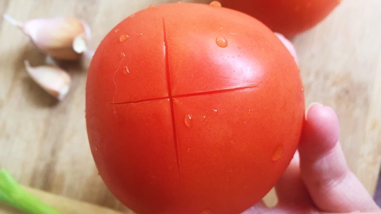 番茄鸡蛋面—家的味道,番茄顶部用刀切十字，方便一会剥皮。