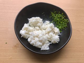 香甜米饭-葱香粢饭糕,将热好的米饭和葱花倒入稍微大一点的碗中。