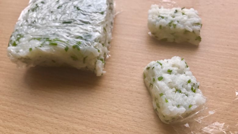 香甜米饭-葱香粢饭糕,然后对半切开，总之切成长3cm，宽2cm，高1cm的长方体。用保鲜膜固定住了形状所以很容易切的。