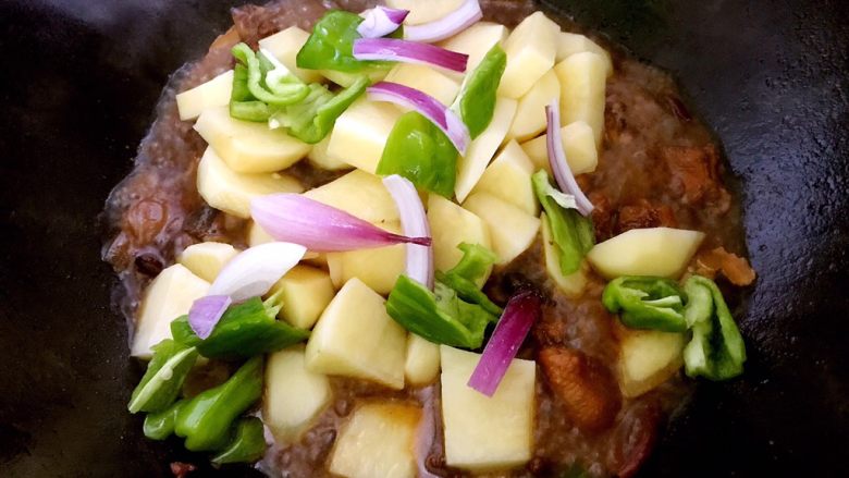 大盘鸡的做法及吃时注意事项,中火煮一会后加入土豆余下的洋葱几片青椒，盖上锅盖，中小火慢炖。