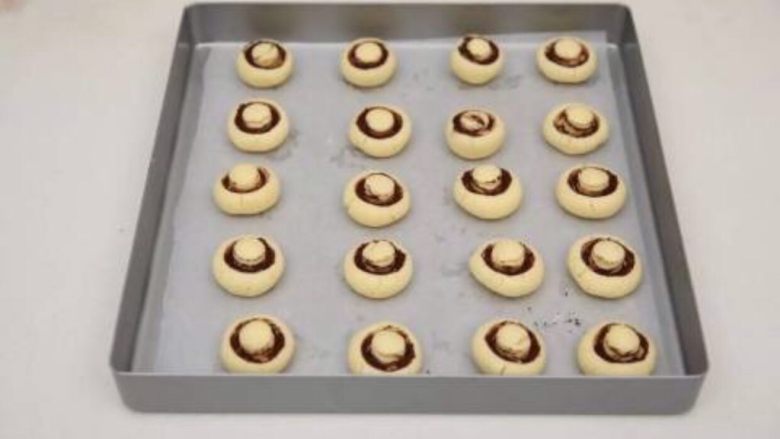 蘑菇饼干,饼干放入垫上油纸的烤盘，要保持一定距离，因为烤的时候会膨胀起来的。
