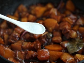 红烧肉炖土豆,待汤汁减少时调入适量盐