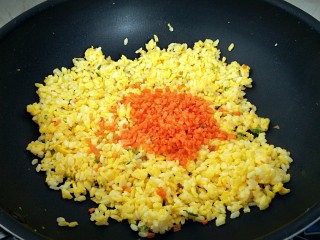 黄金炒饭,米饭炒至松散，倒入胡萝卜翻炒。