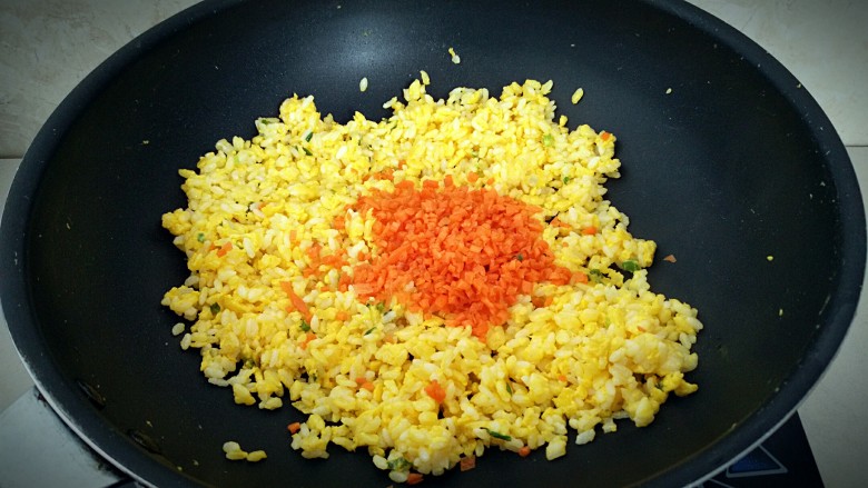 黄金炒饭,米饭炒至松散，倒入胡萝卜翻炒。