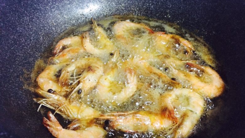 避风塘炒虾,腌好的虾热油炸制定型，表面金黄外脆里嫩，捞出沥干油分