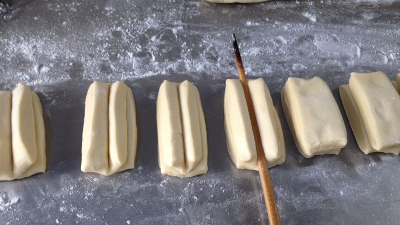 香酥油条,再把俩小条面对面的叠在一起，用筷子在中间用力压下，油条坯子便做好了