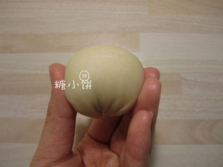 【苏式五仁月饼】,取一个擀卷两次的面剂子，如图把两端往底部收拢，团成一个球形