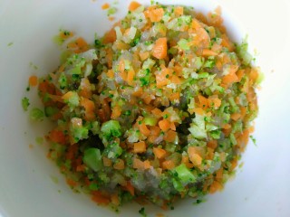 鲜虾蔬菜饼,把切好的胡萝卜和西兰花碎一起放入虾仁碎碗中搅拌均匀。