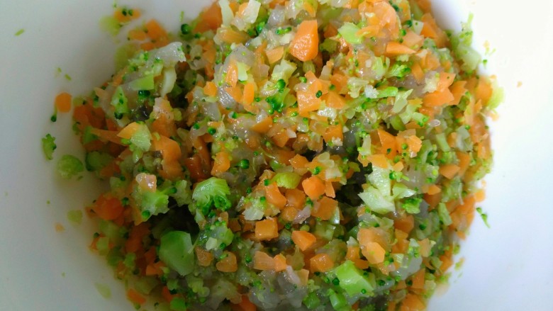 鲜虾蔬菜饼,把切好的胡萝卜和西兰花碎一起放入虾仁碎碗中搅拌均匀。