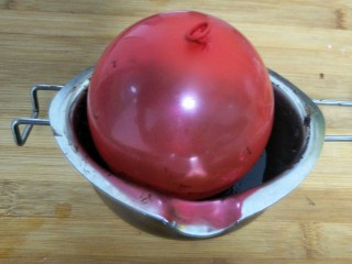 奶油芝士巧克力碗,气球放入巧克力里滚均匀（大概巧克力覆裹住气球的一半）