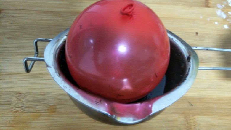 奶油芝士巧克力碗,气球放入巧克力里滚均匀（大概巧克力覆裹住气球的一半）