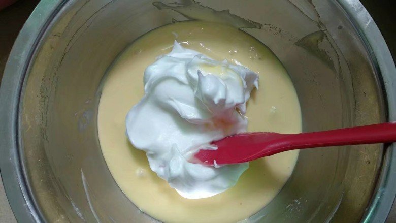 斑马纹戚风蛋糕（8寸版）,取1/3蛋白霜放入蛋黄糊。从下往上翻拌或#字翻拌，不可圈拌以免消泡。