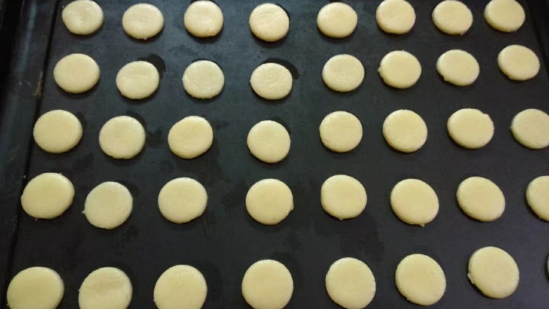 纽扣饼干,将刻好的圆形用小刀轻轻转移到不粘烤盘上，尽量不要变形，之间留间隙。