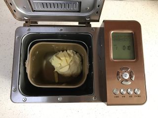 面包机版红枣果仁面包,加入软化的黄油，继续和面10分钟。