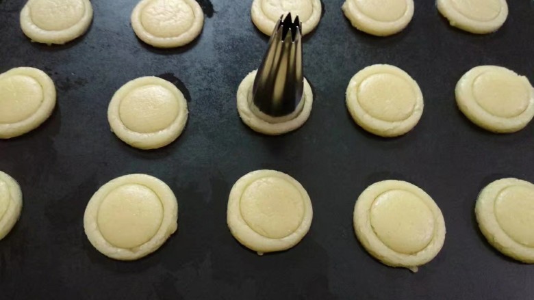 纽扣饼干,再用小一圈的裱花嘴在圆形中间刻出一个浅点的圆圈印子。