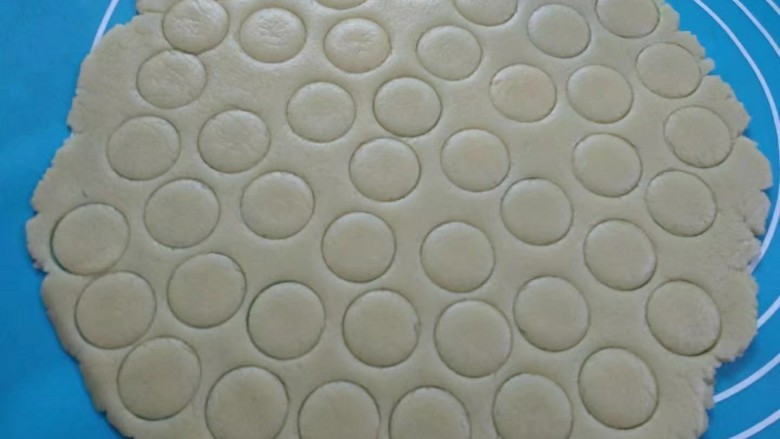 纽扣饼干,将面团放硅胶垫上用擀面杖擀成薄片，用大号裱花嘴刻出圆形。