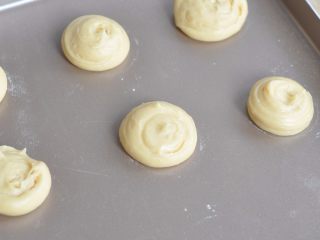 酥皮大泡芙,面糊装入裱花袋中，在烤盘上挤成圆形。