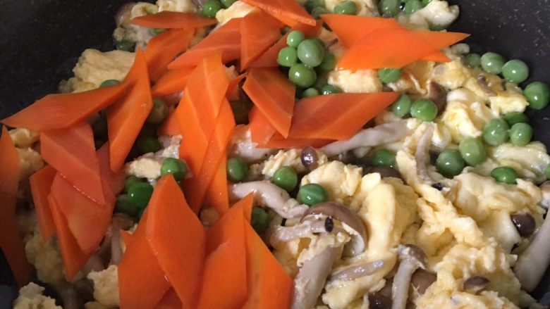 滑蛋蟹味菇,加入碗豆和胡萝卜翻炒均匀