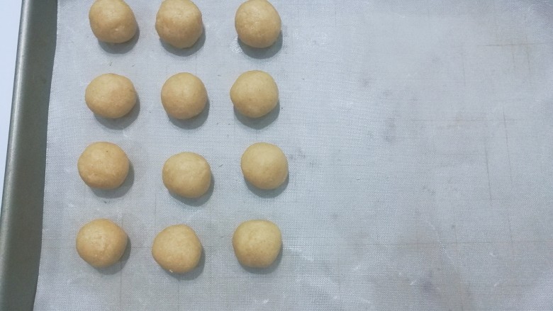 花生小酥饼,将揉好的面团分成每份约10克重的小剂子，并搓成小圆球摆入烤盘中；

