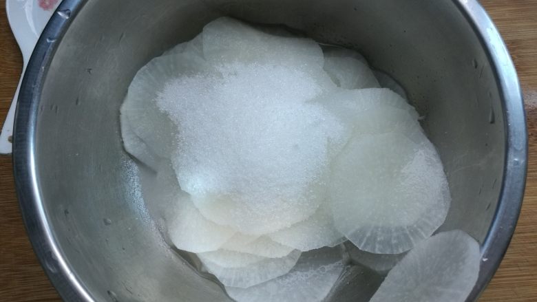 糖醋白萝卜,倒出多余的水分，用清水冲洗几遍，加入白糖。