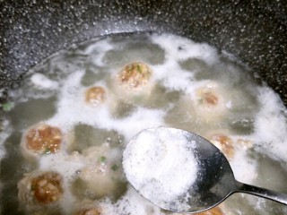 丸子粉丝汤,用勺子撇去浮沫，加入配菜