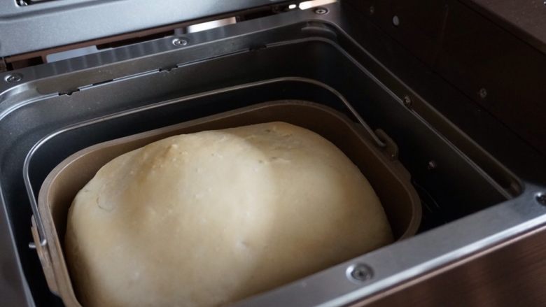 一键式米饭葡萄干面包,烘烤结束，立即戴上隔热手套，提起面包桶把手，将面包倒在晾架上晾凉