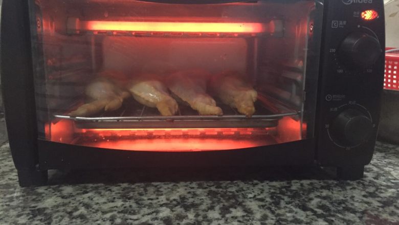 鸡翅包饭,预热后，把鸡翅包饭放入烤箱，用时15-20分钟，温度200°。