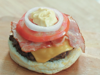 牛肉汉堡,再加上一块切成圆形的番茄，再加上洋葱、黄油，挤上沙拉酱。