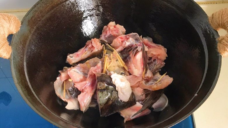 干锅鱼头,腌制好的鱼头沥干水分倒入锅里，这个时候不能去翻拌，煎2到3分钟再翻面煎