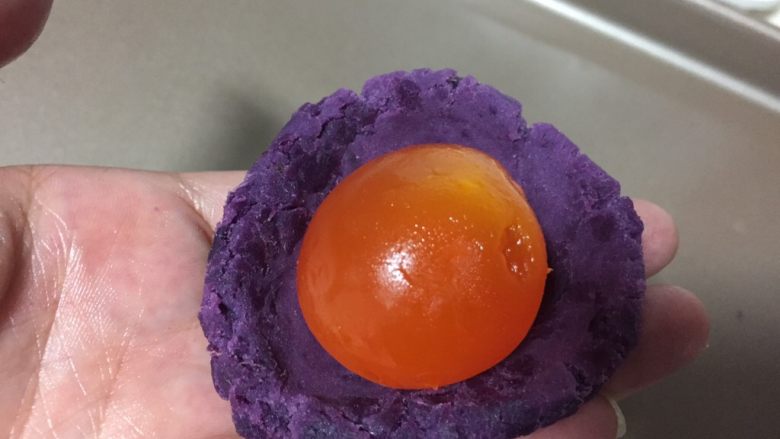 紫薯蛋黄酥,紫薯和蛋黄称重一共43克左右。
紫薯捏成薄的圆片中间放一个蛋黄，把蛋黄包起来。