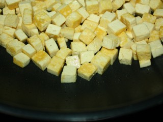 美味下饭宫保豆腐,锅内加少许油，放入豆腐小火慢煎，至表面金黄即盛出待用。