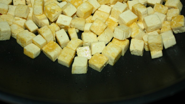 美味下饭宫保豆腐,锅内加少许油，放入豆腐小火慢煎，至表面金黄即盛出待用。