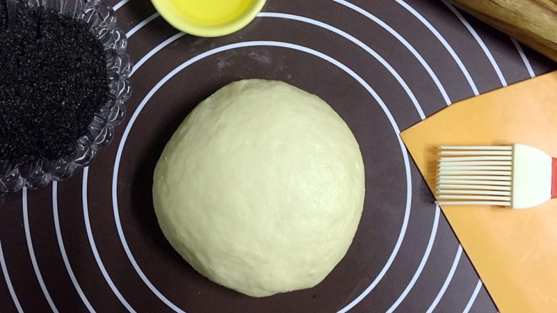 有内涵的辫子面包系列之--黑芝麻,面包面团经过1个小时左右的揉面、一次发酵后，取出，排气揉圆
