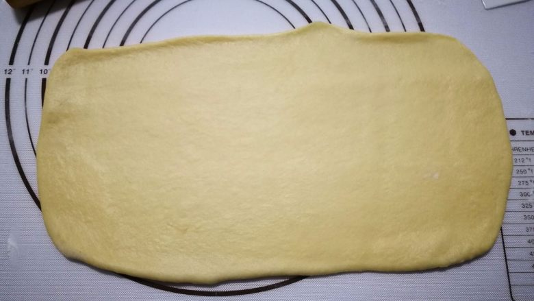 奶香法棍型面包,拿一个面团用擀面仗擀成长方形，上面那边稍微薄一点