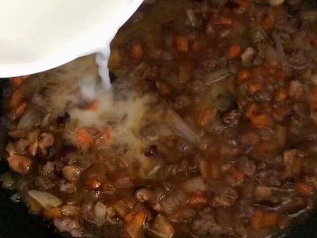 儿童牛肉香菇肉酱,慢慢倒入锅内勾芡，铲子边搅拌。