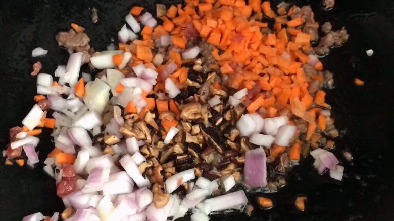 儿童牛肉香菇肉酱,接着放洋葱末，胡萝卜，香菇末炒出香味。