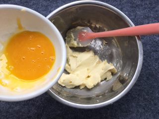 花生芝麻小酥饼,倒入细砂糖，鸡蛋取蛋黄打散倒入盘中，留一小部分下来，等一下刷表面蛋液。
