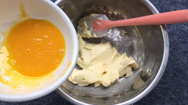 花生芝麻小酥饼,倒入细砂糖，鸡蛋取蛋黄打散倒入盘中，留一小部分下来，等一下刷表面蛋液。
