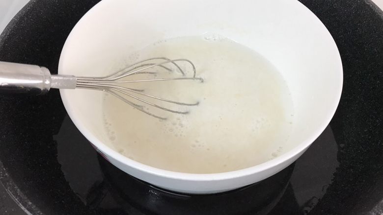 芒果牛奶千层糕,同样的隔热水搅拌均匀至糖和吉利丁粉完全融化