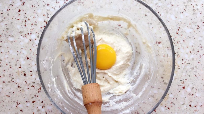 纸杯戚风蛋糕,分次加入蛋黄，用同样的手法拌均匀；