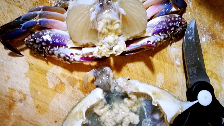 家庭简易版螃蟹海鲜粥,把螃蟹盖取下，盖子里的蟹黄留好，把盖子顶部中间的小沙袋剪下。