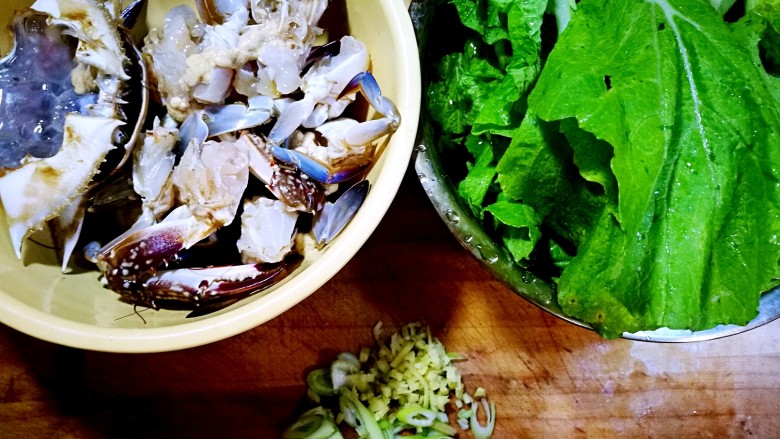 家庭简易版螃蟹海鲜粥,一只螃蟹随意剪成四块，小青菜洗好，葱姜切沫。