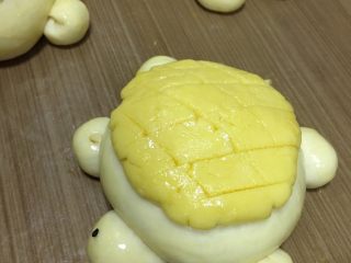 萌小龟面包,在表面刷一层全蛋液，再用黑芝麻给它们装饰上眼睛，烤箱170度预热