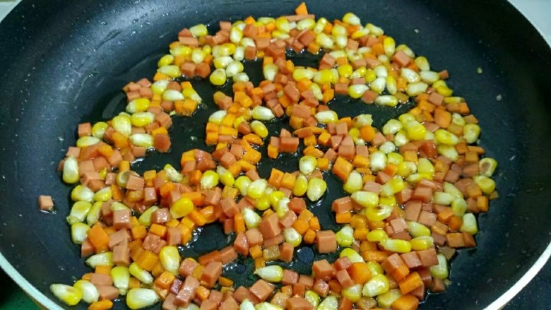 玉米火腿蛋炒饭,倒入火腿翻炒均匀。