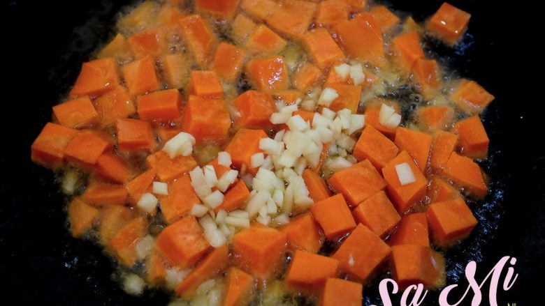 素三丁,开大火烧锅，锅内注入一勺食用油，放入胡萝卜丁和蒜末翻炒均匀