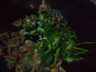 青椒肉丝炒米饭,肉变色之后，倒入葱，青椒翻炒