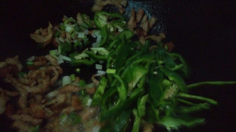 青椒肉丝炒米饭,肉变色之后，倒入葱，青椒翻炒